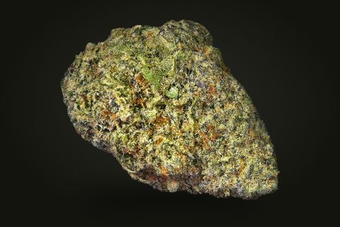 Banana Brain from another side: an oval, dense bud with orange hairs and a purple-grey base, on a plain black background.