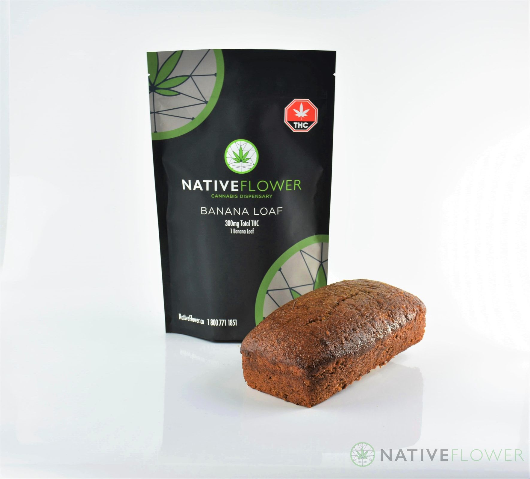 A Native Flower banana loaf standing beside its black stand-up pouch.