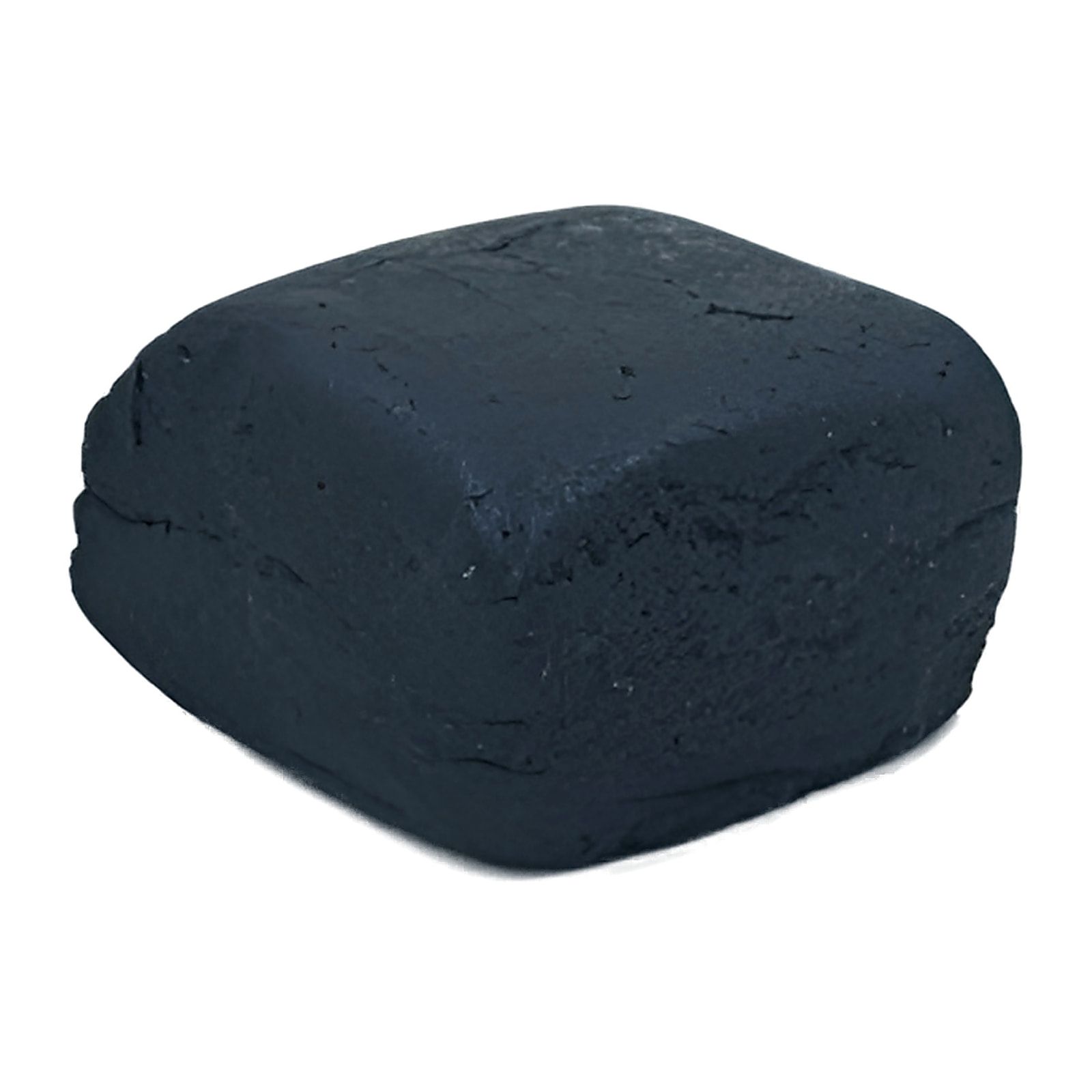 A pressed block of black hash photographed on a white background, its cut faces and pressing seams visible.