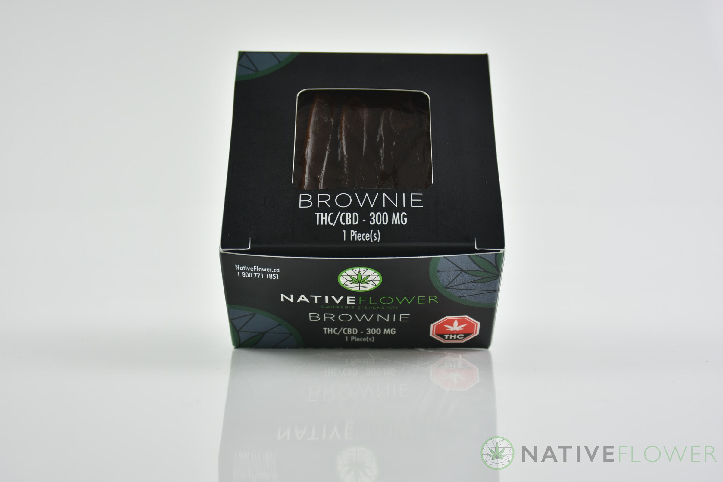A Native Flower brownie seen through the window in its black carton.