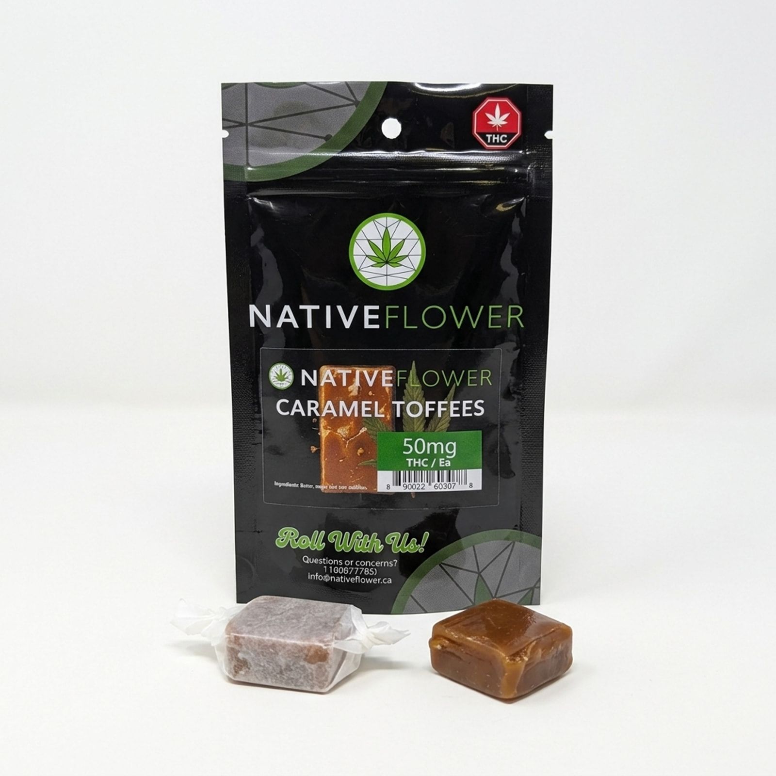 Two caramel toffees, one in a twist of wax paper and one unwrapped, in front of their black Native Flower pouch on a white background.