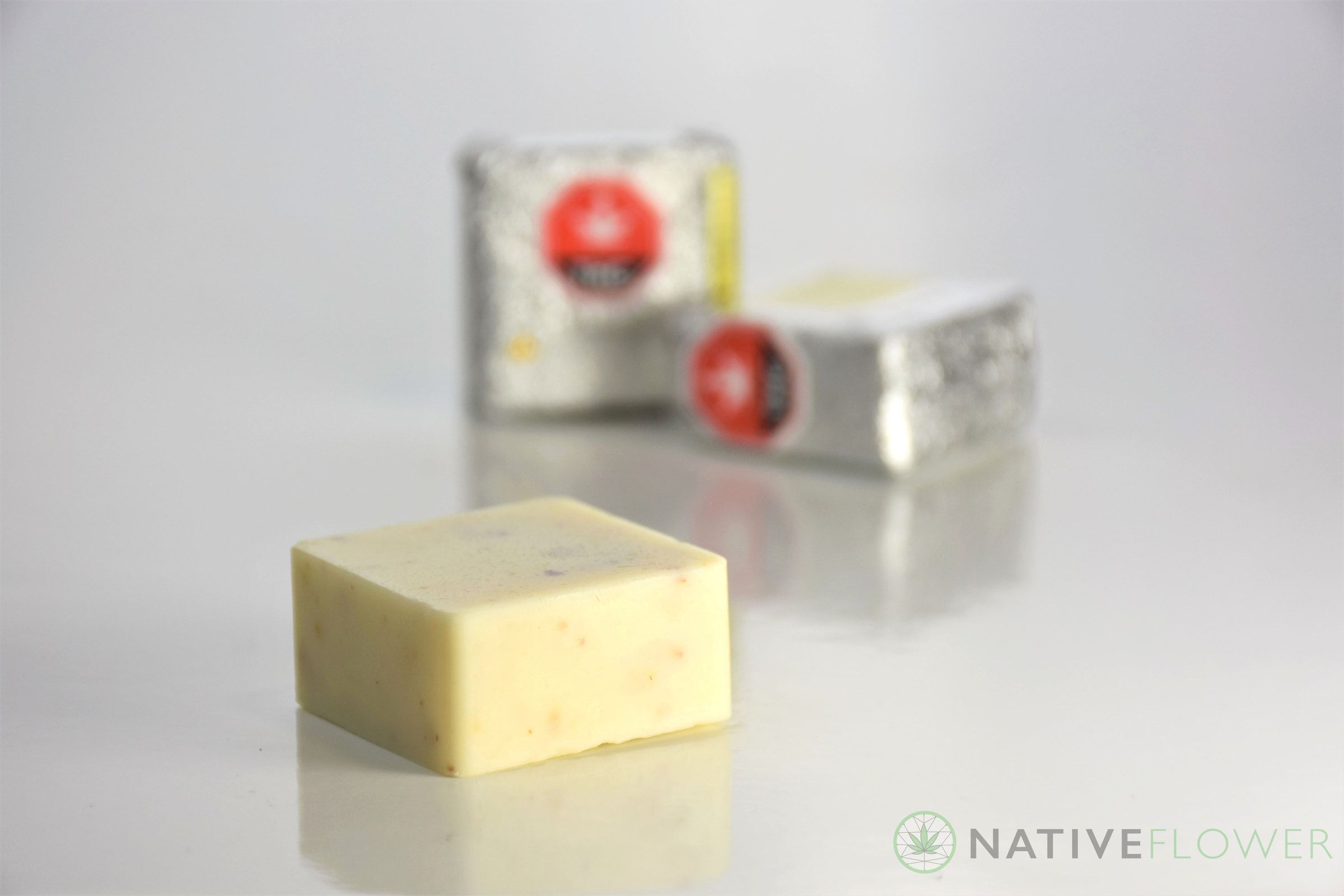 An unwrapped cookies-and-cream square in front of two foil-wrapped ones.