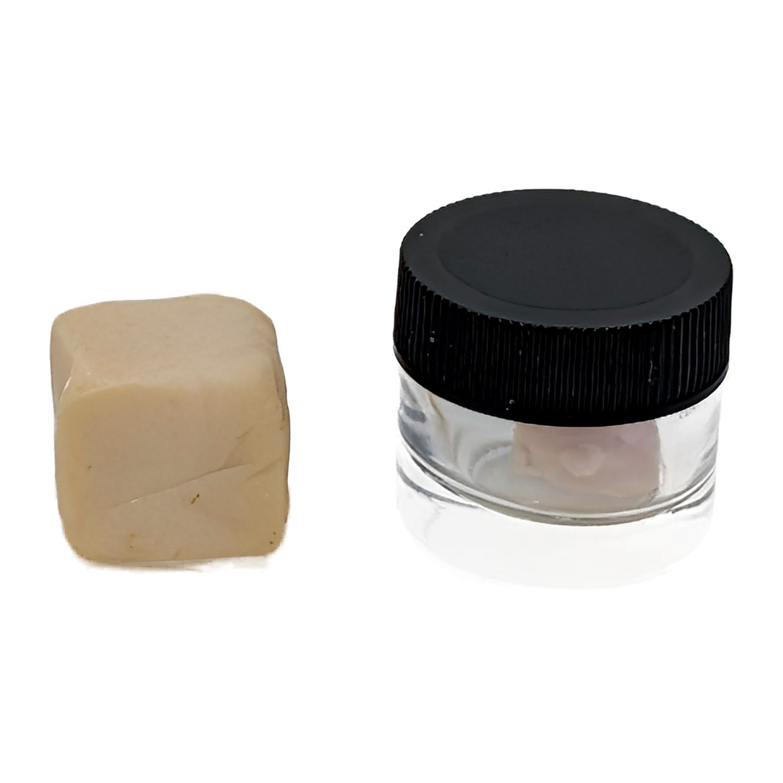 A pale block of diamond hash next to a small glass jar of it with a black screw lid.