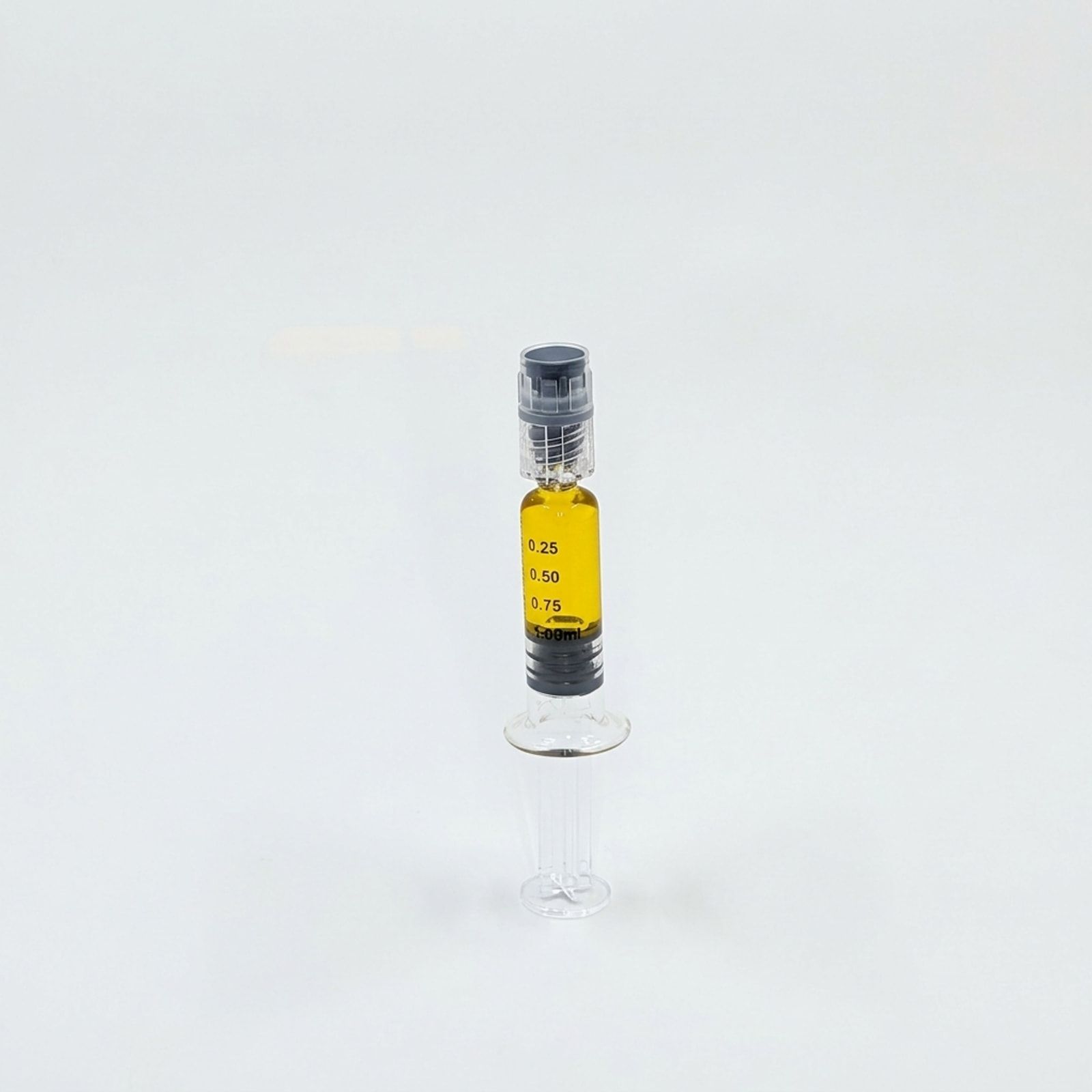 A single syringe of golden distillate standing upright on a white background.