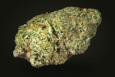 Firewalker OG from another side: a long, dense bud with short orange hairs, on a plain black background.