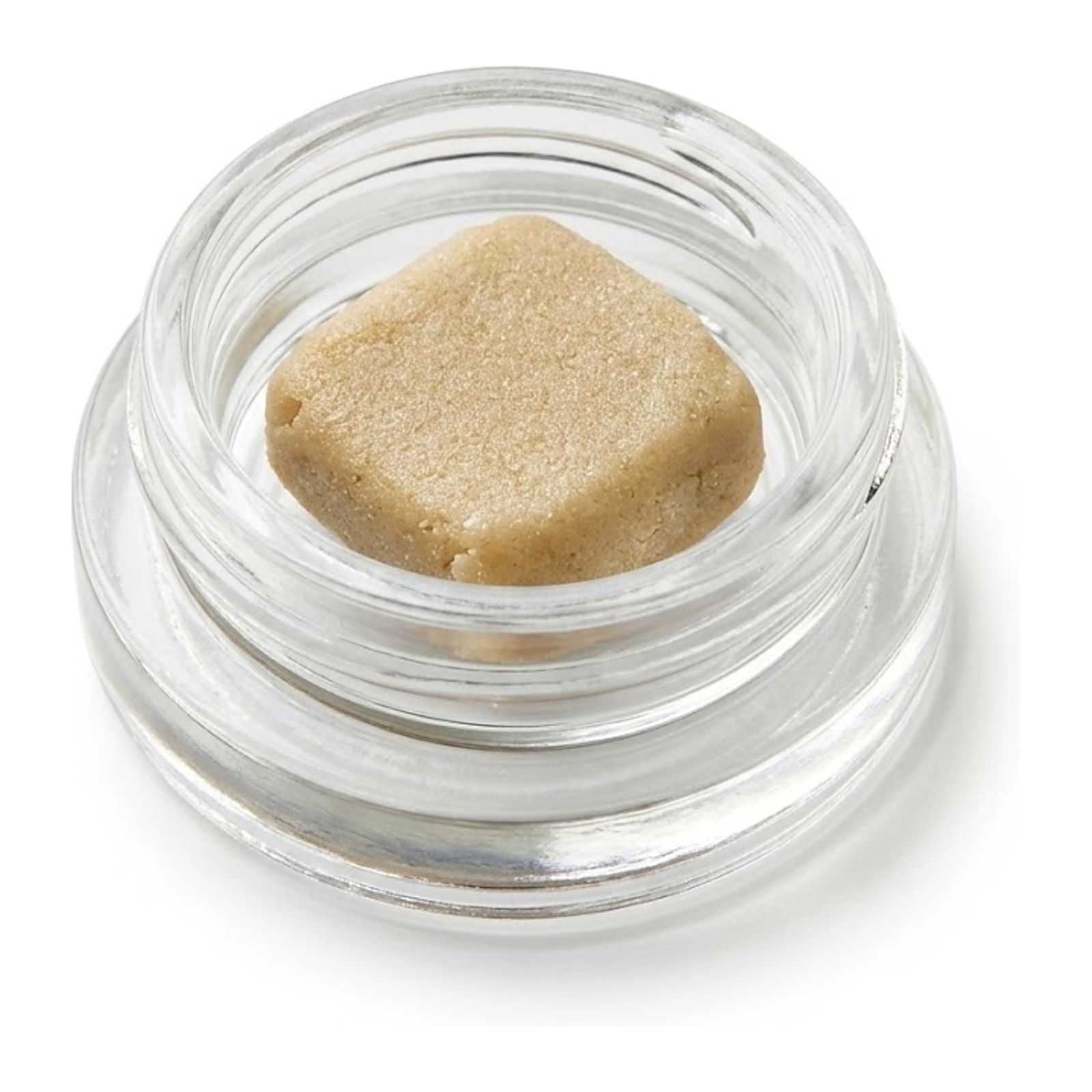 A pale gold patty of full melt hash in an open glass concentrate jar, on a white background.