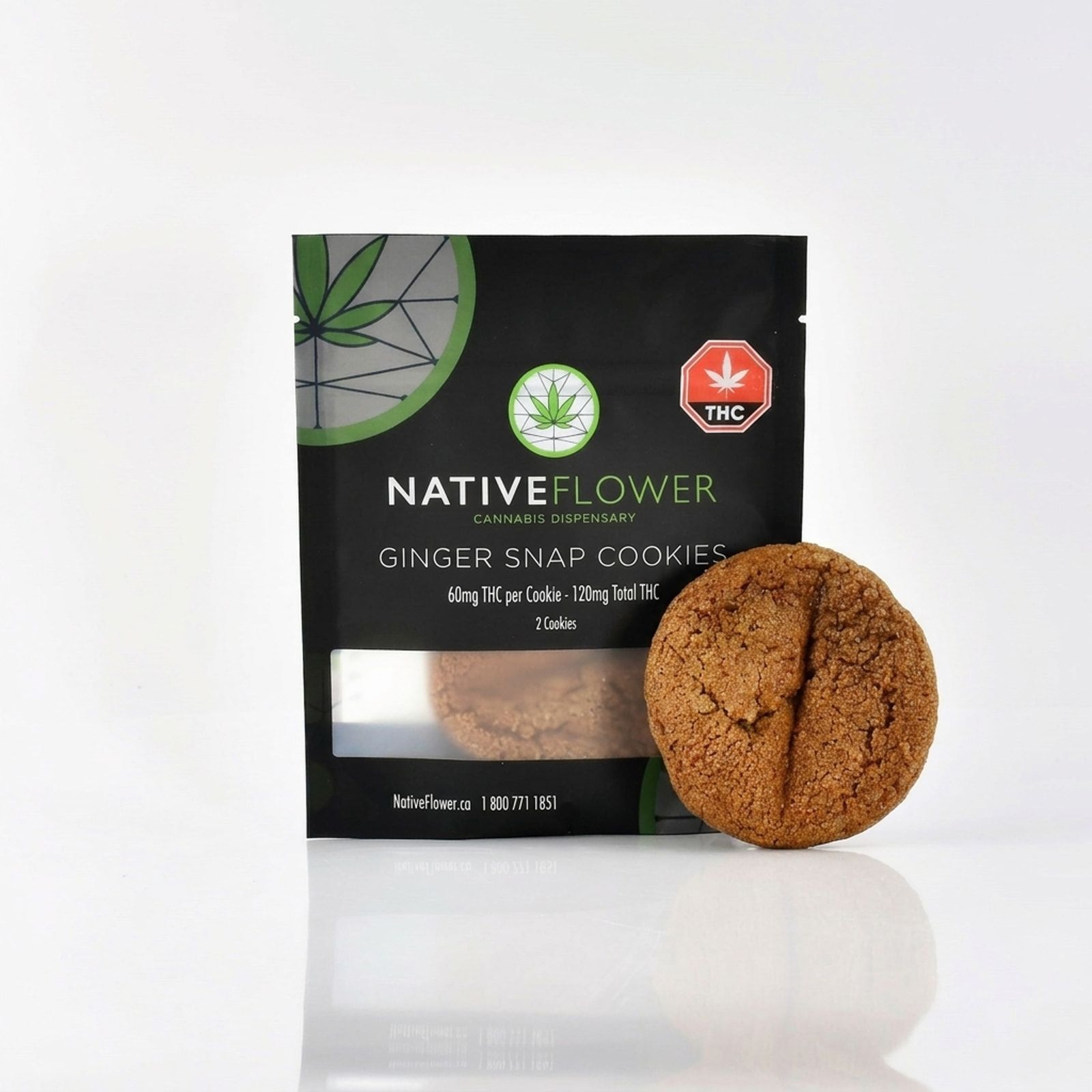 A ginger snap cookie leaning against its black Native Flower pouch on a white background.