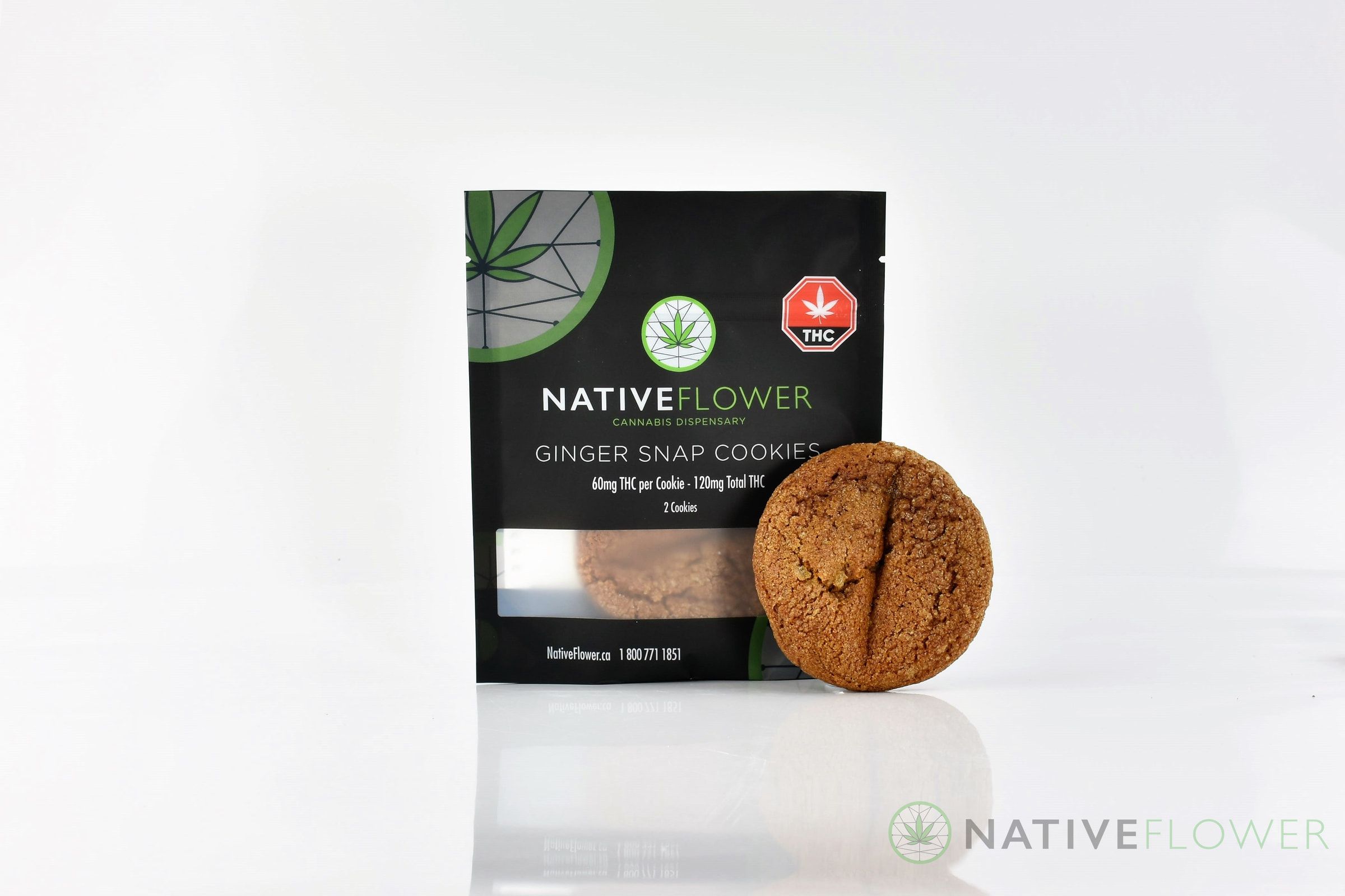 A Native Flower ginger snap cookie leaning against its black pouch.
