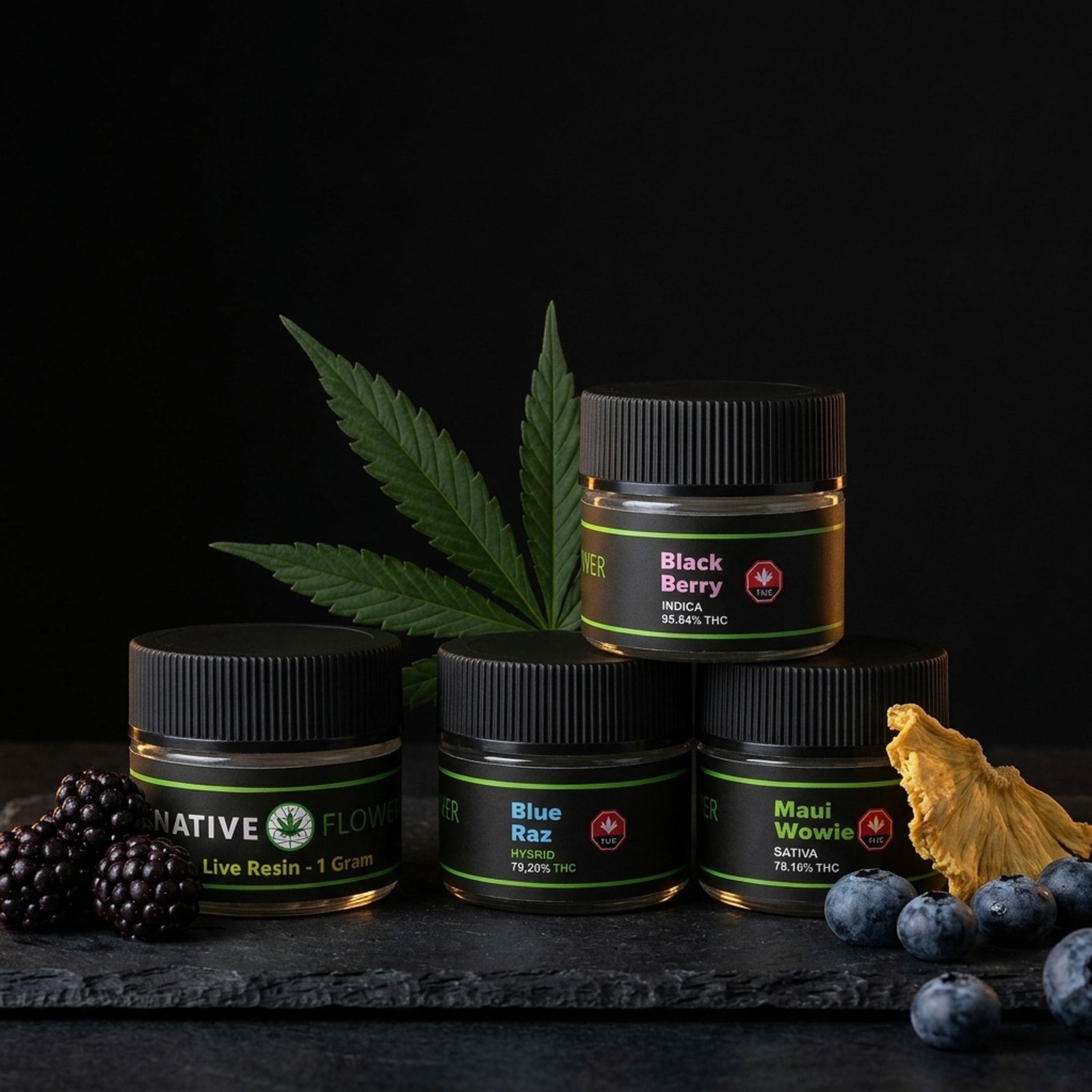 Four Native Flower live resin jars stacked in a pyramid on slate, with a cannabis leaf, blackberries, blueberries and dried pineapple.
