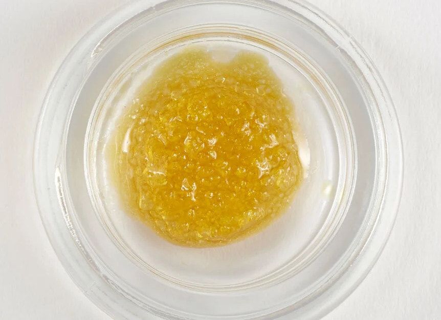 Live resin seen from above in an open jar, pale gold and granular.