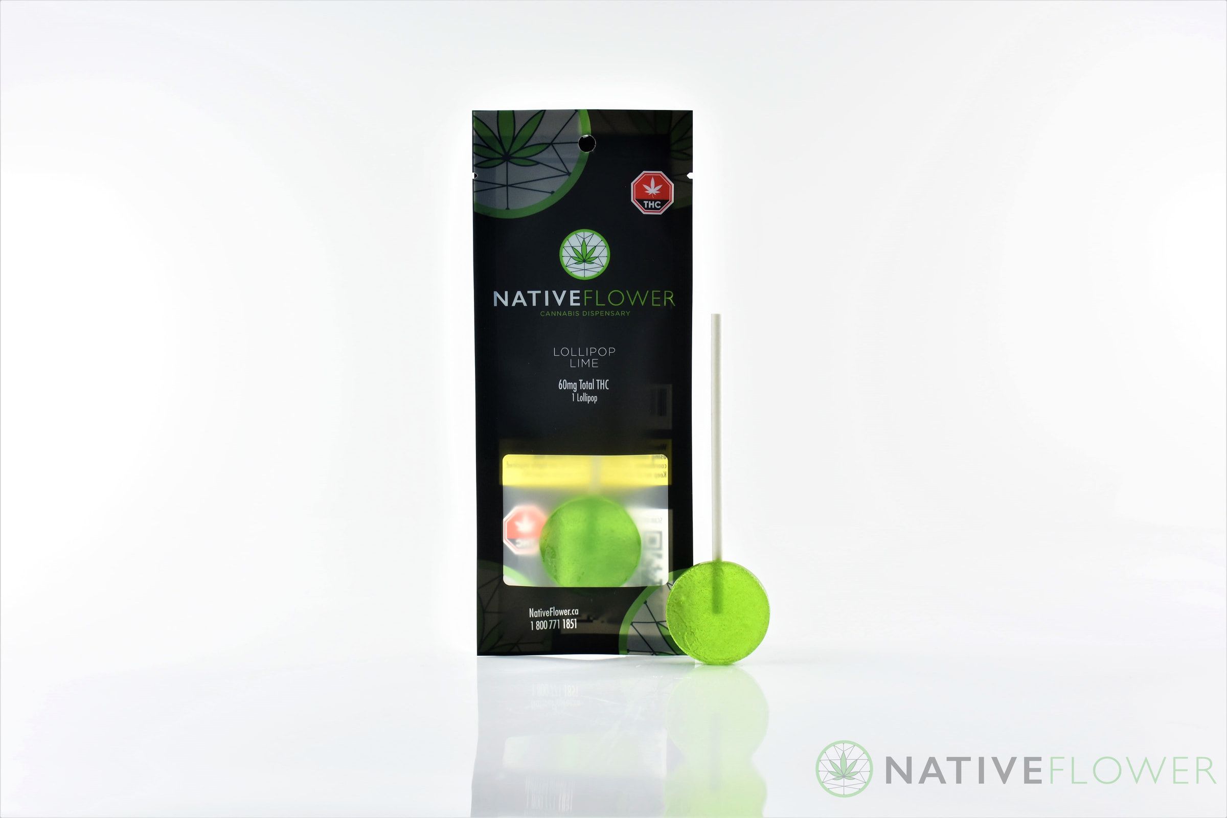A green lollipop standing beside its pouch.