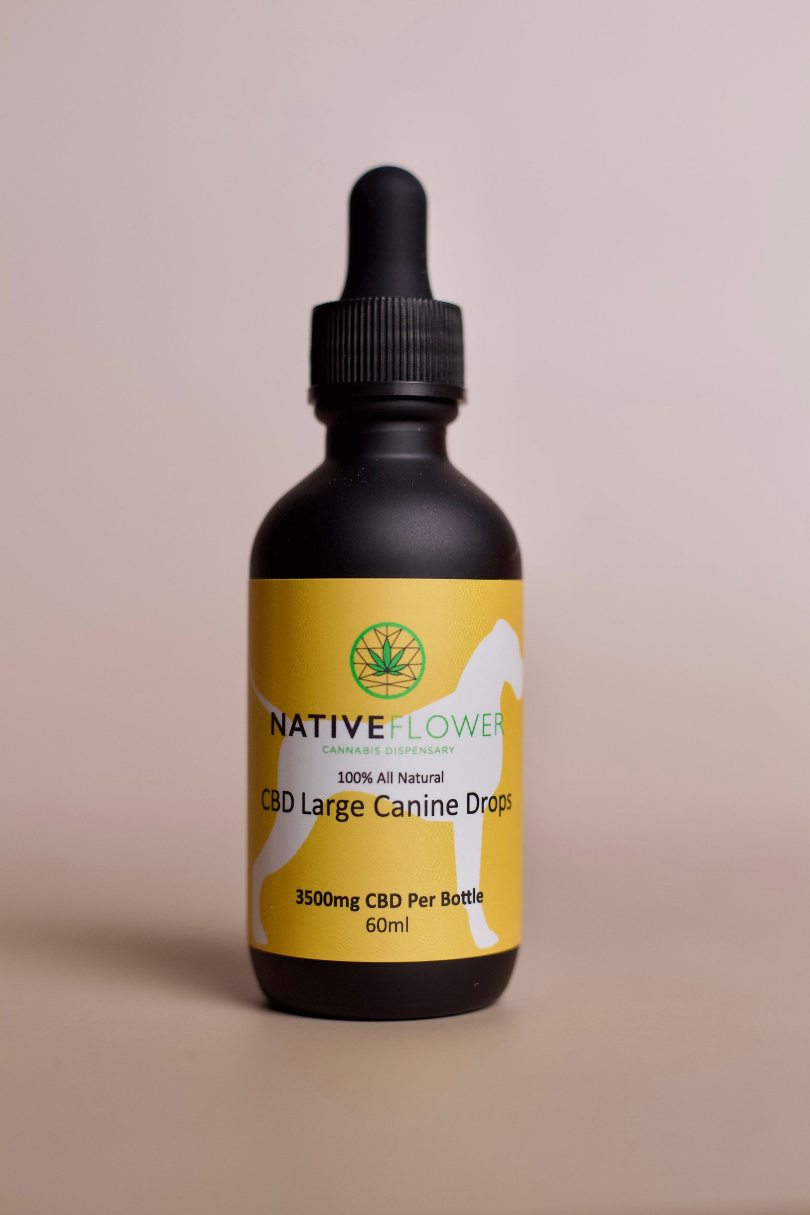 A black dropper bottle with a yellow label showing a dog in silhouette.
