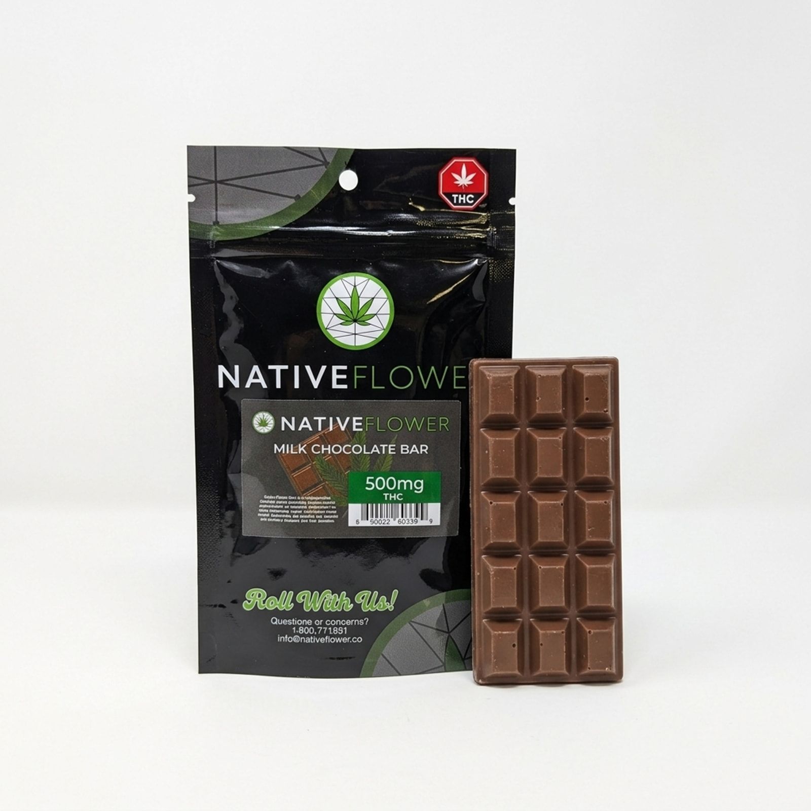 A black Native Flower milk chocolate bar pouch with an unwrapped mini bar leaning against it, on a white background.