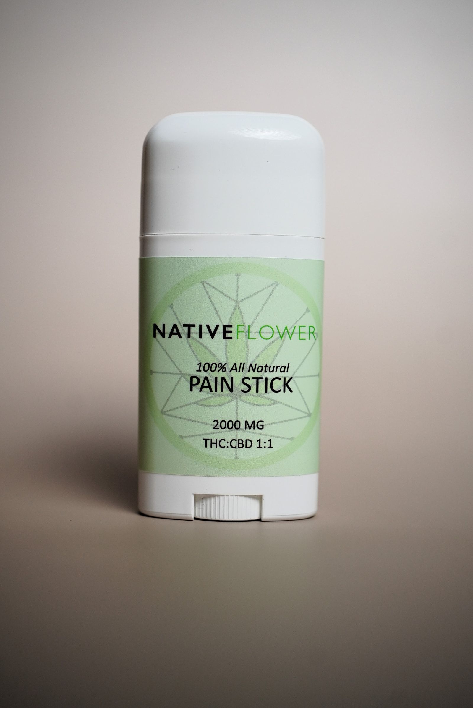 A white Native Flower stick applicator with a green label, cap on.