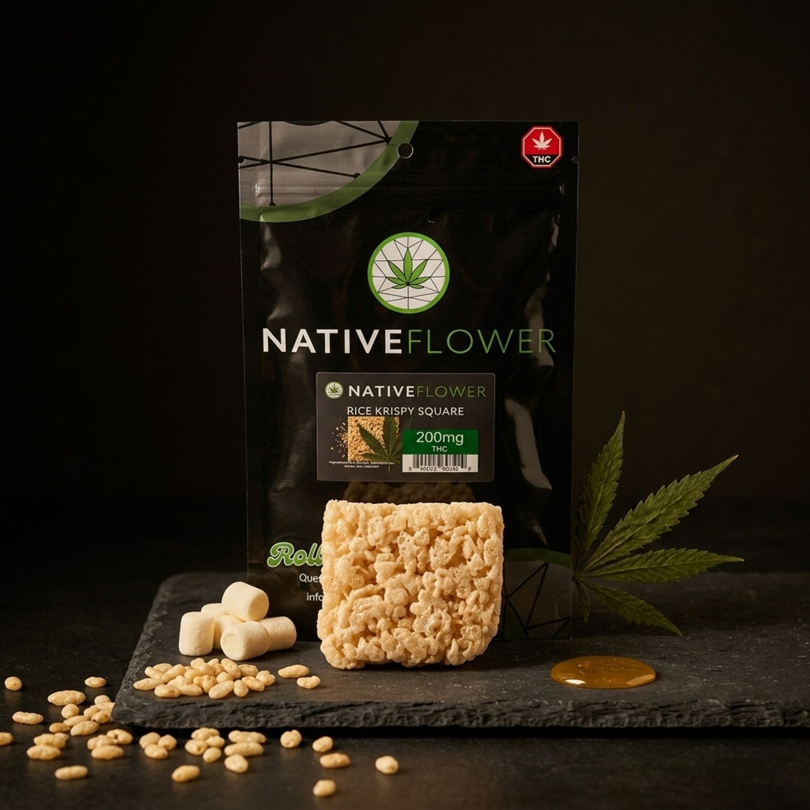 A Native Flower rice krispy square on slate in front of its black pouch, with marshmallows, puffed rice and a cannabis leaf around it.
