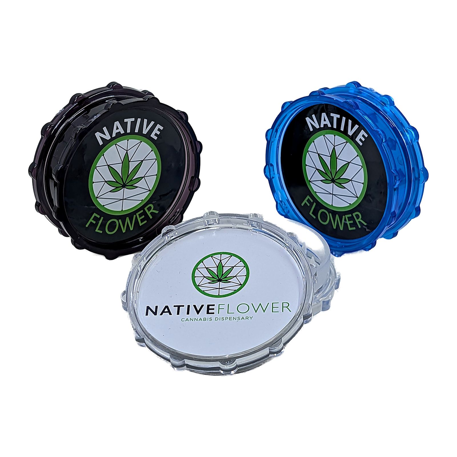 Three Native Flower plastic grinders, in black, blue and clear, two standing upright behind one lying flat with its lid facing up.