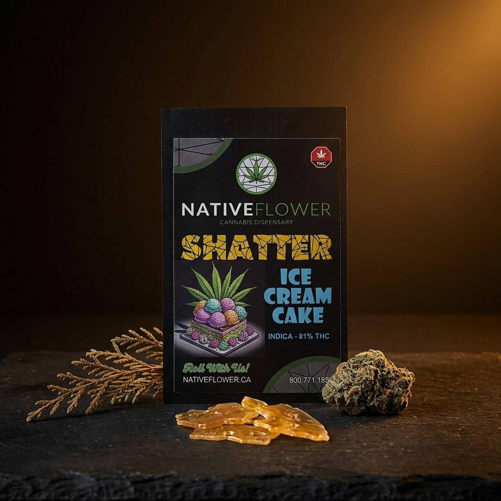 A black Native Flower shatter pouch for Ice Cream Cake on slate, amber shards of shatter in front beside a cannabis bud and cedar.