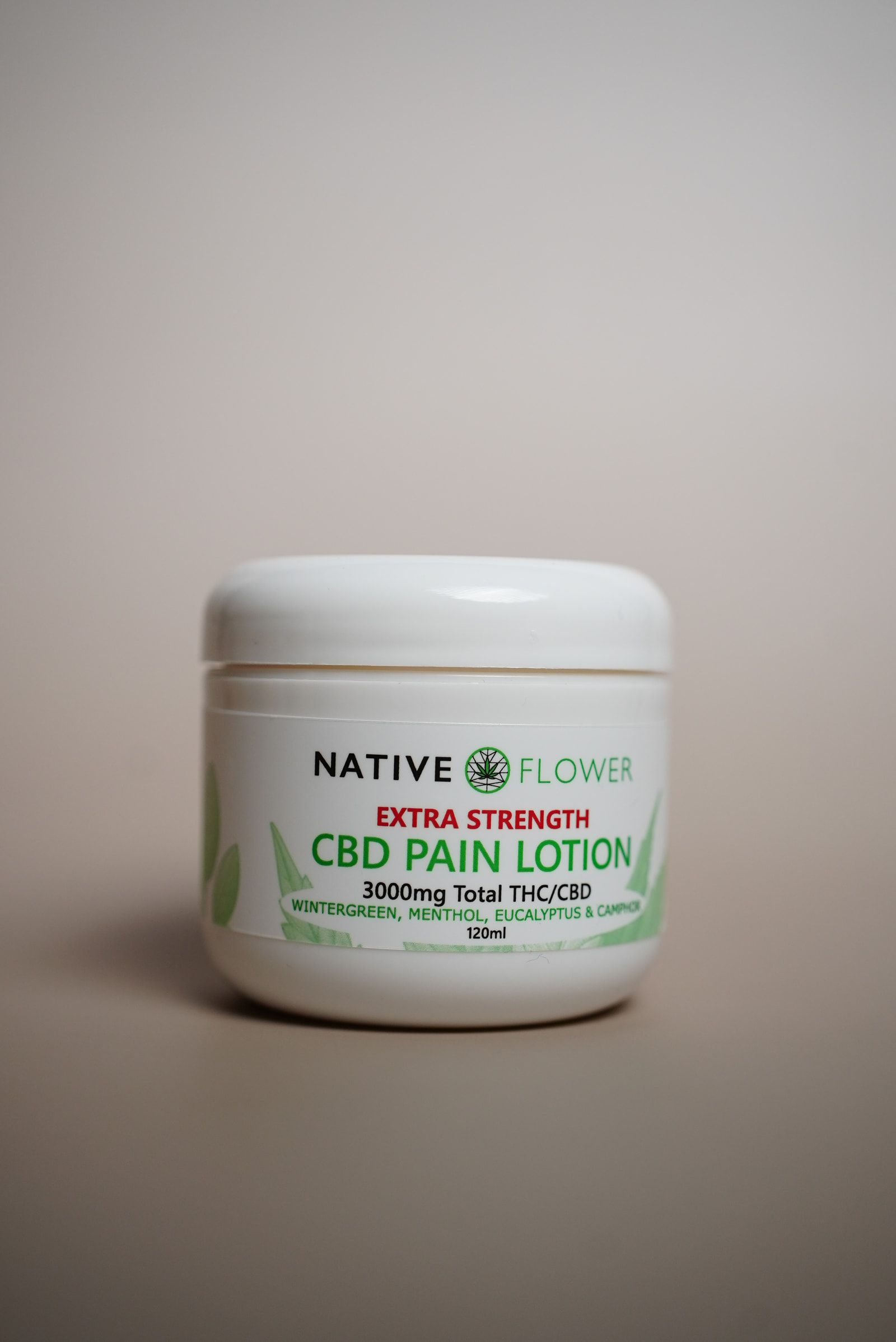 A white tub of Native Flower CBD lotion standing on a pale background.