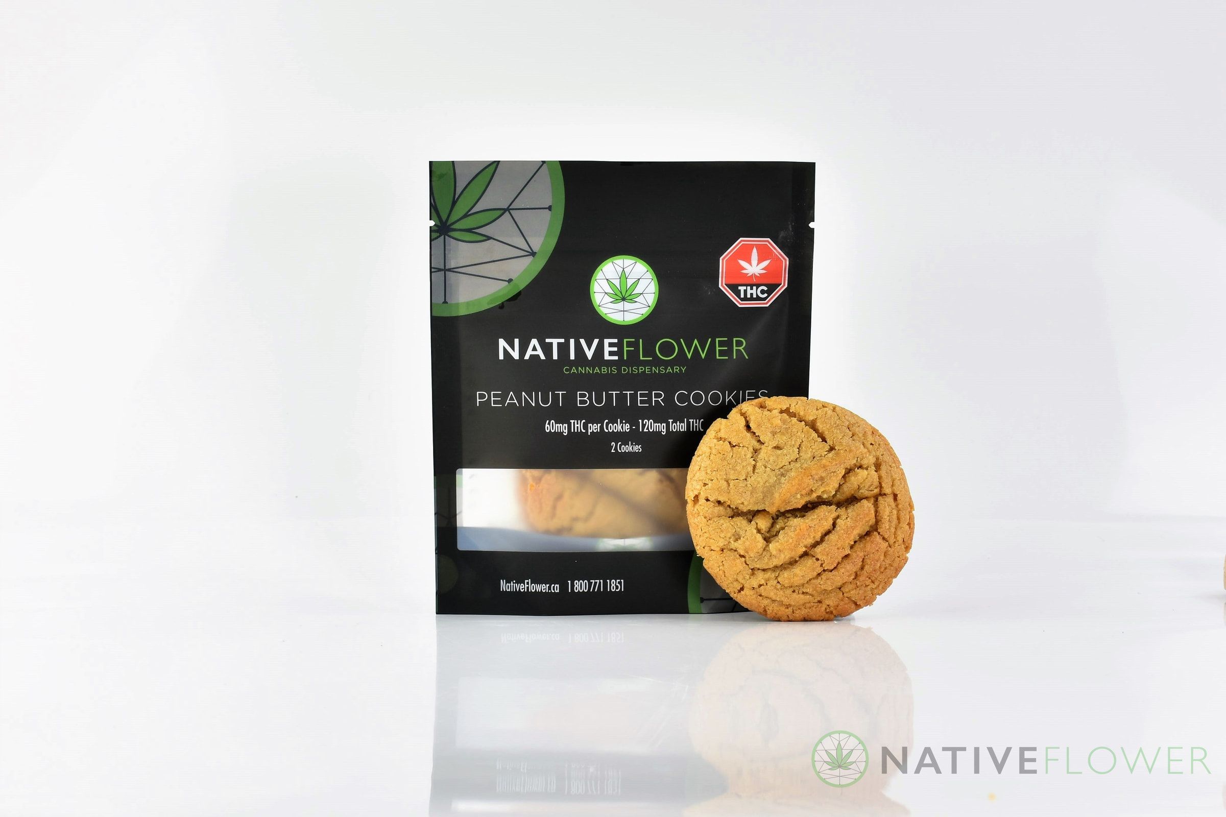 A Native Flower peanut butter cookie leaning against its black pouch.
