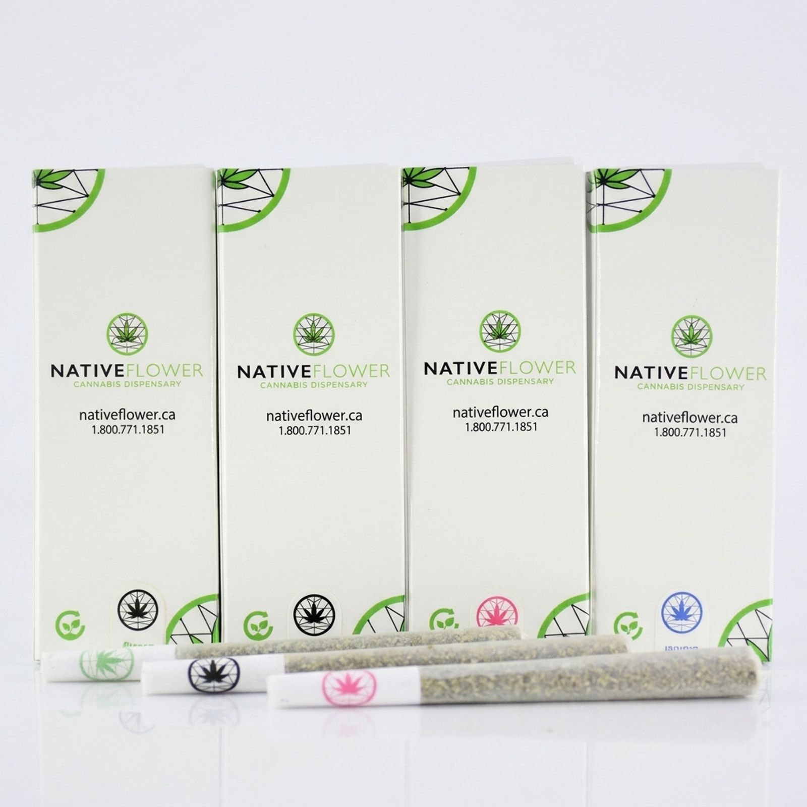 Four white Native Flower pre-roll boxes in a row on a white background, with three pre-rolls lying in front of them.