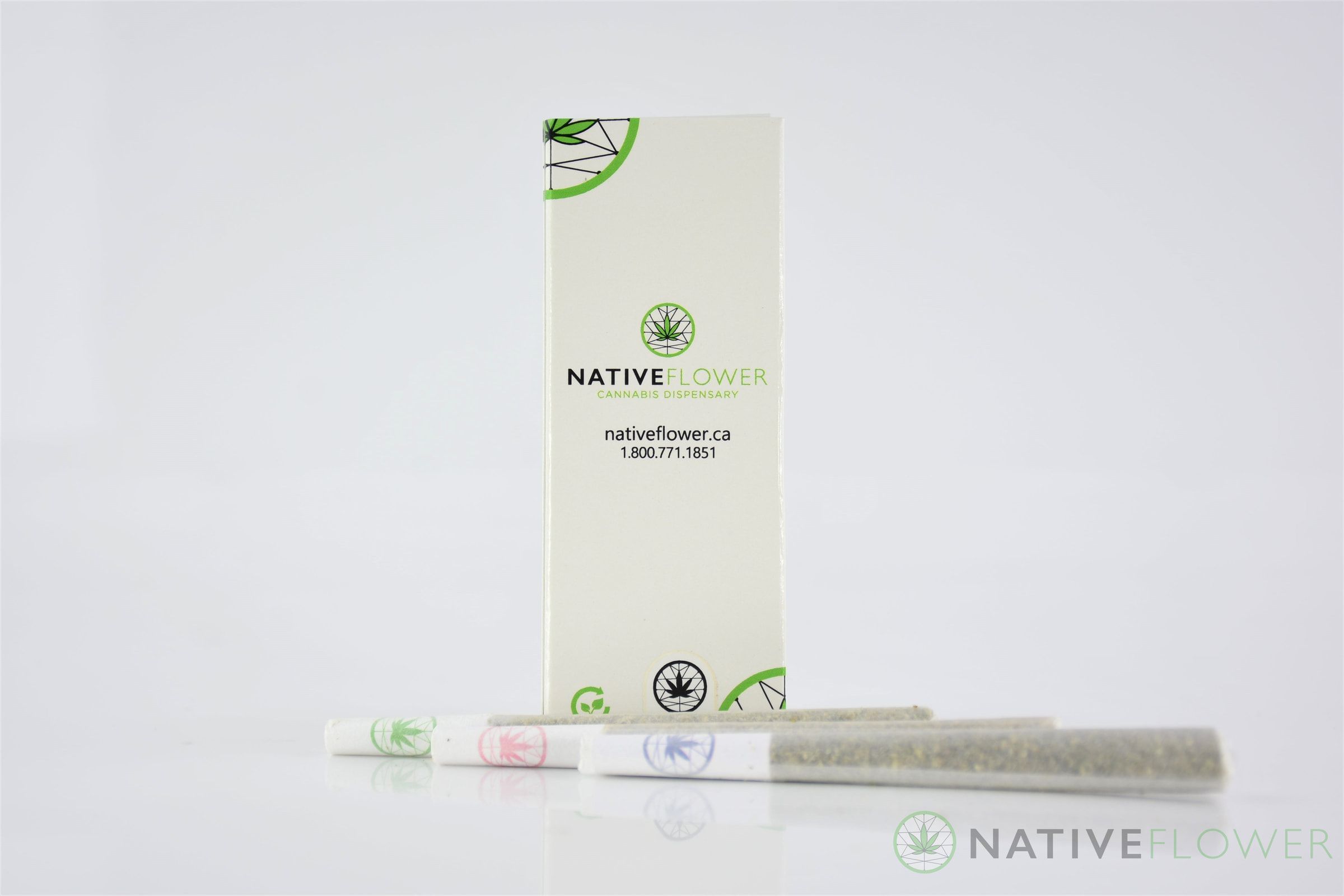 Three Native Flower pre-rolls lying in front of a cream carton.