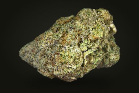 A cured bud of Starfighter, wide and olive green with a tan-purple tint under a fine frost, on a plain black background.
