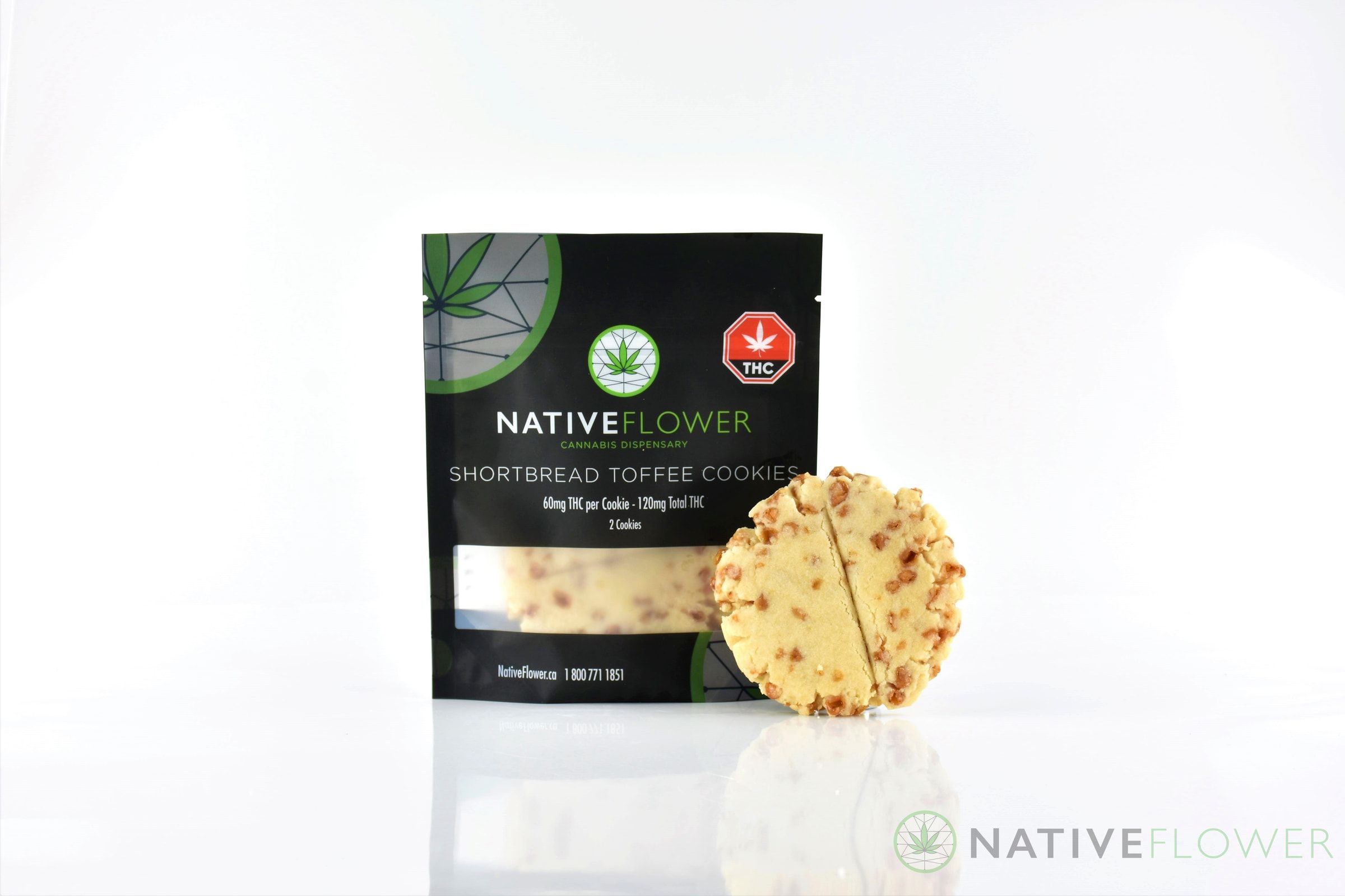 A toffee-flecked Native Flower shortbread cookie leaning against its black pouch.