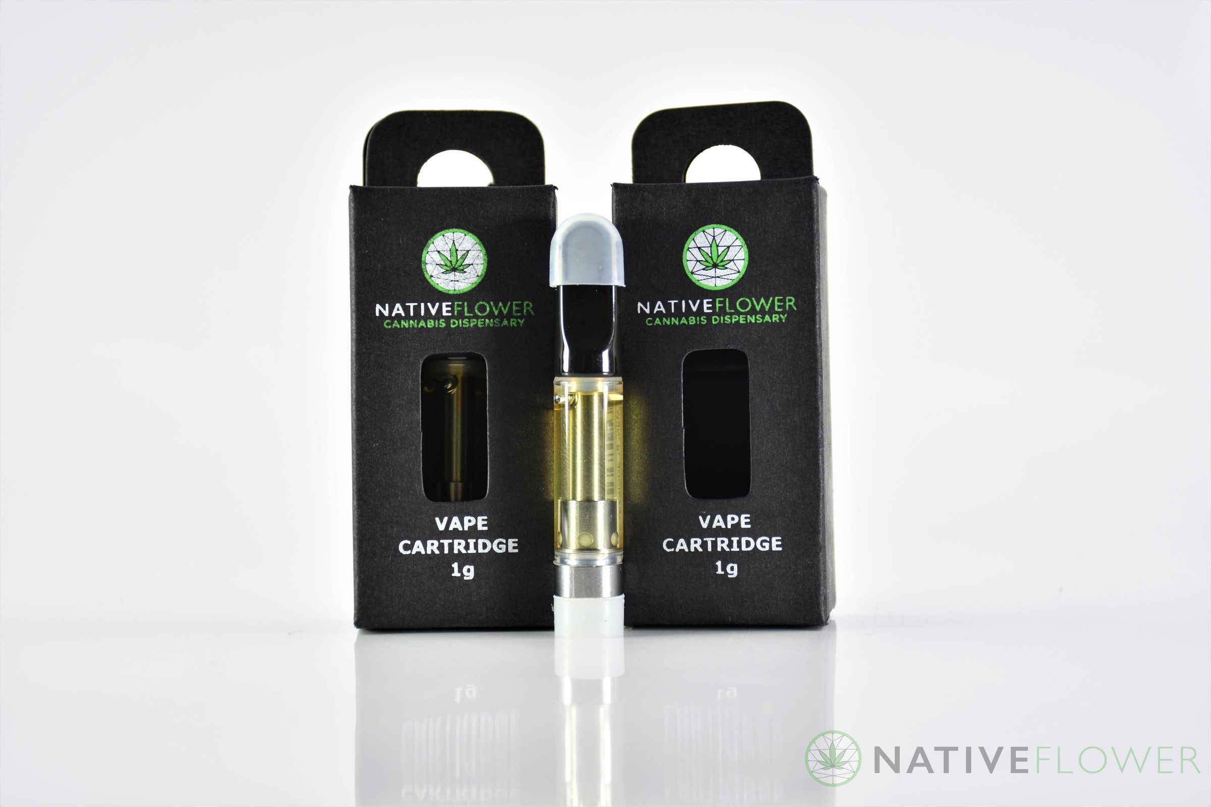 A Native Flower vape cartridge standing between two black retail boxes.